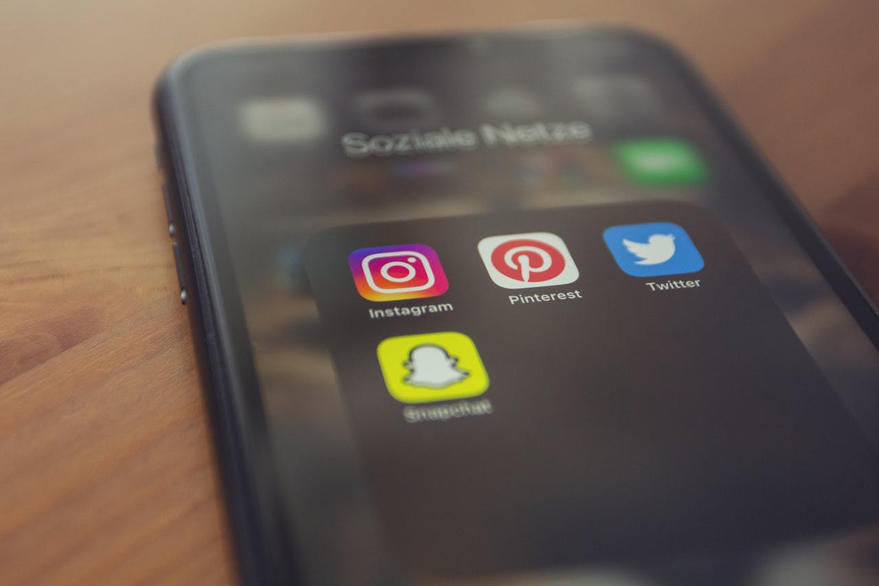 Smartphone displaying popular social media apps like Instagram, Pinterest, Twitter, and Snapchat.